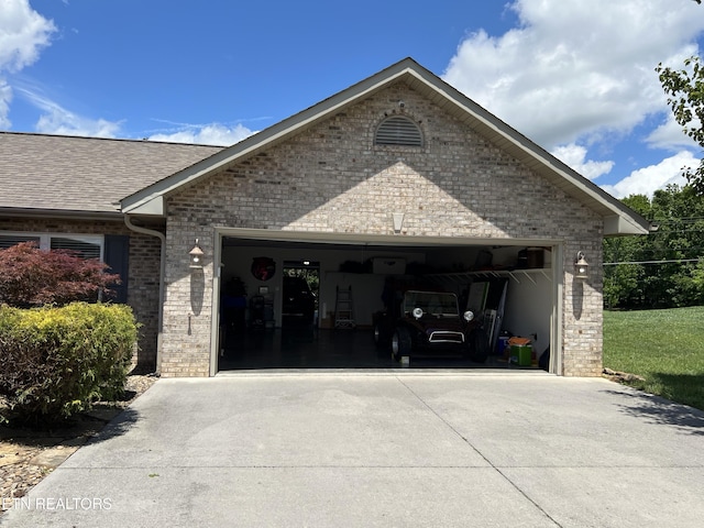 1018 Southwind Cir, Dandridge, TN 37725 - view of home's exterior featuring concrete driveway, an attached garage, brick siding, and a shingled roof