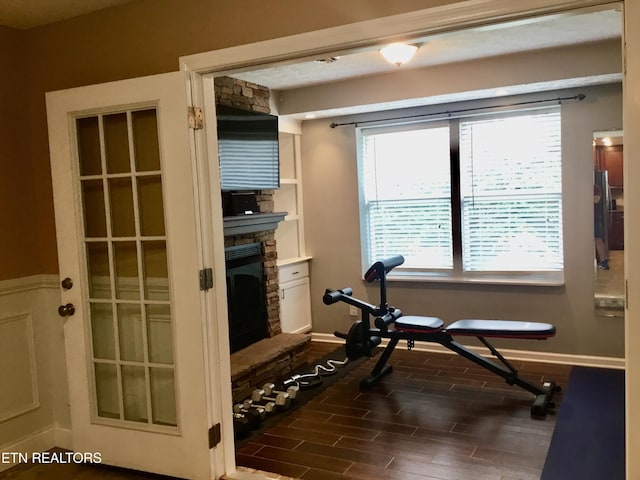 1018 Southwind Cir, Dandridge, TN 37725 - workout room featuring dark wood-style floors, a stone fireplace, and baseboards