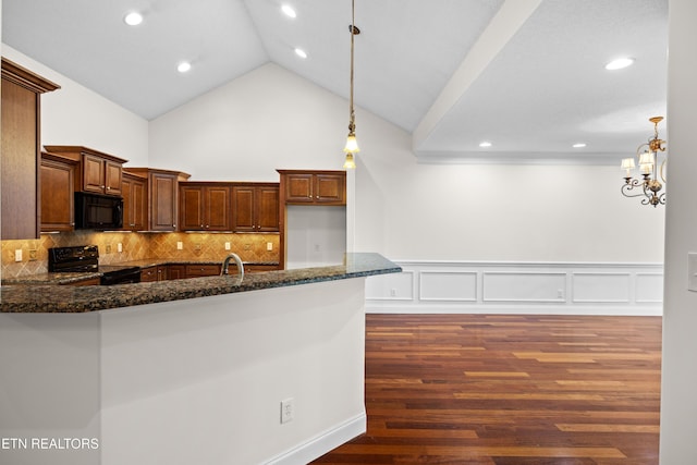 7235 Alysha Vineyard Way, Knoxville, TN 37931 - kitchen featuring black appliances, dark stone countertops, a wainscoted wall, hanging light fixtures, and dark wood finished floors