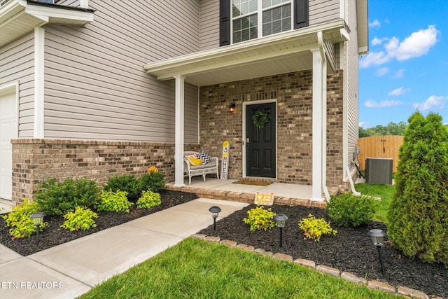 2516 Lemon Berry St, Knoxville, TN 37932 - doorway to property featuring brick siding, covered porch, central AC unit, and an attached garage