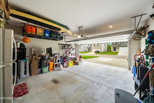 2516 Lemon Berry St, Knoxville, TN 37932 - garage featuring a garage door opener, freestanding refrigerator, and recessed lighting