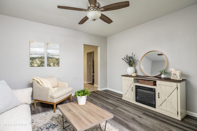 6944 Berry Ln, Knoxville, TN 37914 - living room with dark wood-style flooring, ceiling fan, baseboards, and a glass covered fireplace