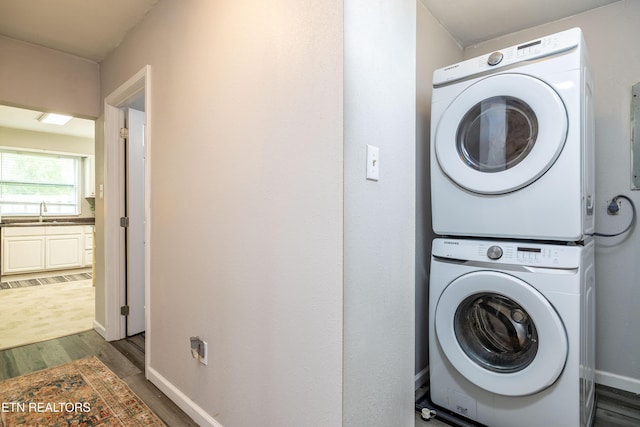 6944 Berry Ln, Knoxville, TN 37914 - laundry room with stacked washer / drying machine, wood finished floors, and baseboards