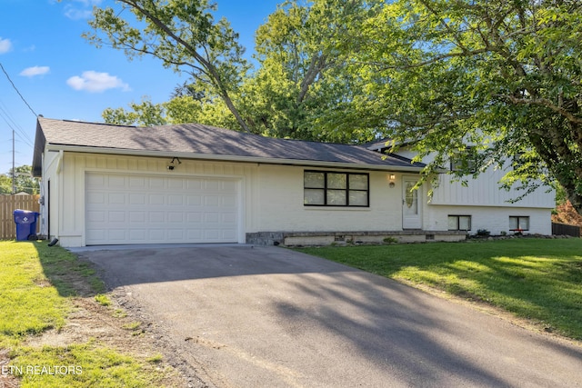 828 Noragate Rd, Knoxville, TN 37919 - tri-level home featuring asphalt driveway, a garage, a front lawn, and brick siding