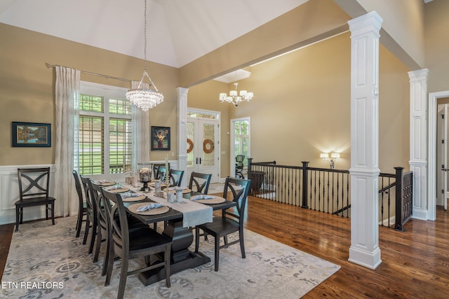 111 Winchester Cir, Oak Ridge, TN 37830 - dining space featuring a chandelier, high vaulted ceiling, wood finished floors, ornate columns, and wainscoting