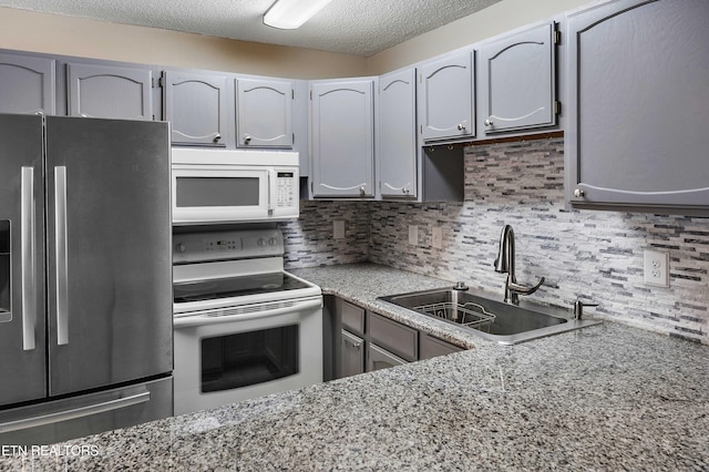 1316 Mountain Meadows Way, Sevierville, TN 37862 - kitchen with white appliances, a sink, tasteful backsplash, light stone countertops, and a textured ceiling