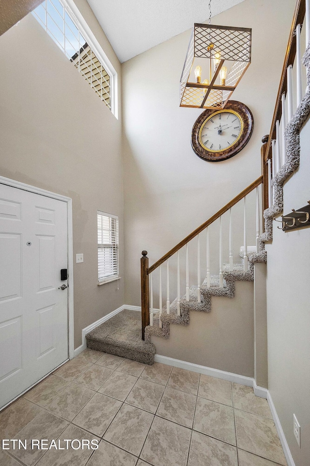 1316 Mountain Meadows Way, Sevierville, TN 37862 - foyer with a chandelier, stairs, a towering ceiling, baseboards, and tile patterned floors