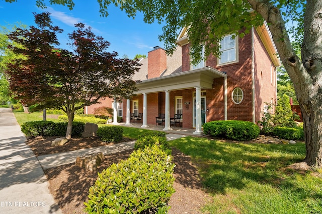 12311 Willow Ridge Ln, Farragut, TN 37934 - view of front of house with brick siding, covered porch, a chimney, and a front lawn