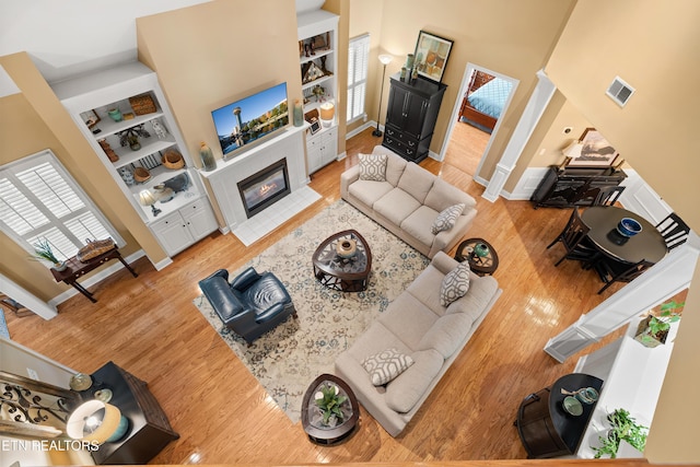 12311 Willow Ridge Ln, Farragut, TN 37934 - living room featuring wood finished floors, built in shelves, baseboards, and a towering ceiling