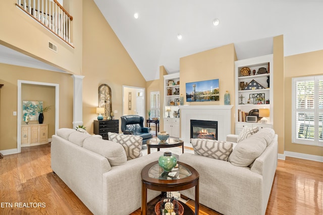 12311 Willow Ridge Ln, Farragut, TN 37934 - living area featuring high vaulted ceiling, baseboards, a tile fireplace, light wood-style floors, and ornate columns