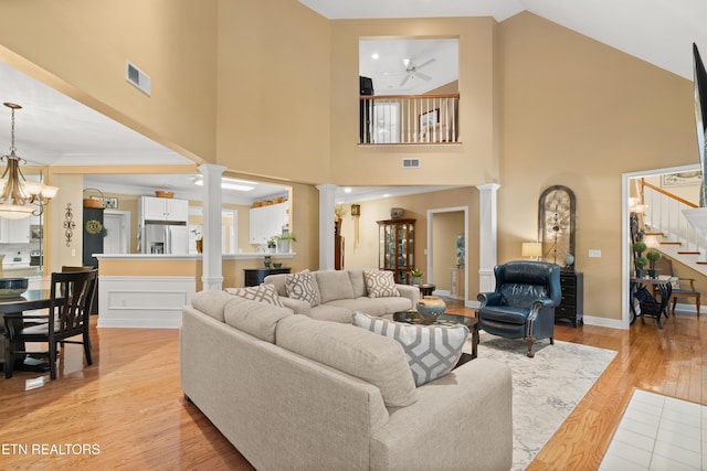 12311 Willow Ridge Ln, Farragut, TN 37934 - living room featuring decorative columns, stairs, light wood-style floors, a high ceiling, and ceiling fan