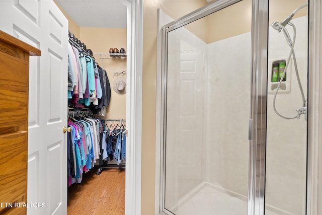 12311 Willow Ridge Ln, Farragut, TN 37934 - full bathroom with a stall shower, a walk in closet, and wood finished floors