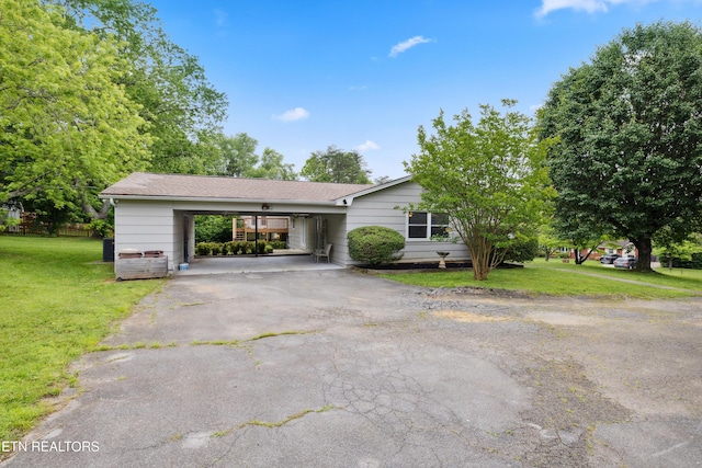7613 Luscombe Dr, Knoxville, TN 37919 - view of front of home featuring driveway, a front lawn, a carport, and a shingled roof