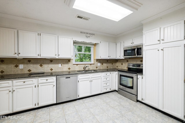 7613 Luscombe Dr, Knoxville, TN 37919 - kitchen featuring appliances with stainless steel finishes, a sink, crown molding, decorative backsplash, and white cabinets