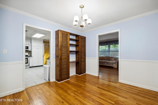 7613 Luscombe Dr, Knoxville, TN 37919 - unfurnished dining area featuring wainscoting, light wood finished floors, a chandelier, and crown molding