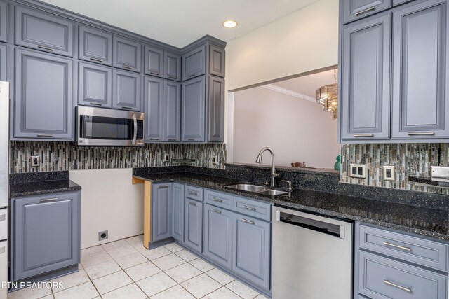 1025 Ree Way Unit 20, Knoxville, TN 37909 - kitchen with stainless steel appliances, a sink, decorative backsplash, crown molding, and dark stone counters