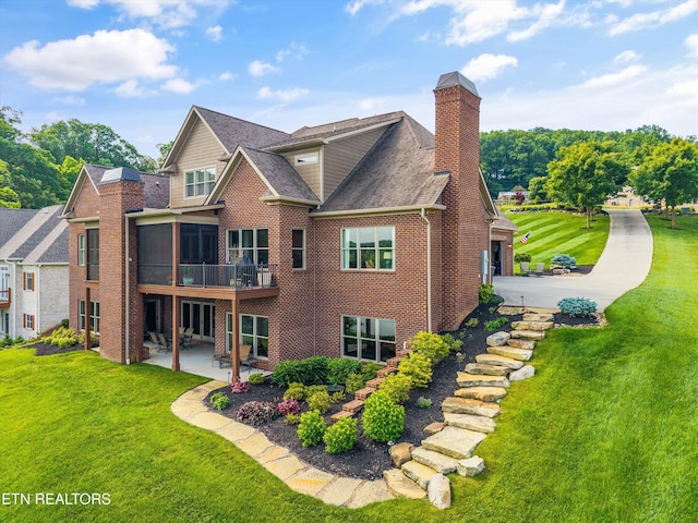 436 Silent River Ln, Loudon, TN 37774 - back of house featuring a patio area, brick siding, a yard, a sunroom, and a chimney