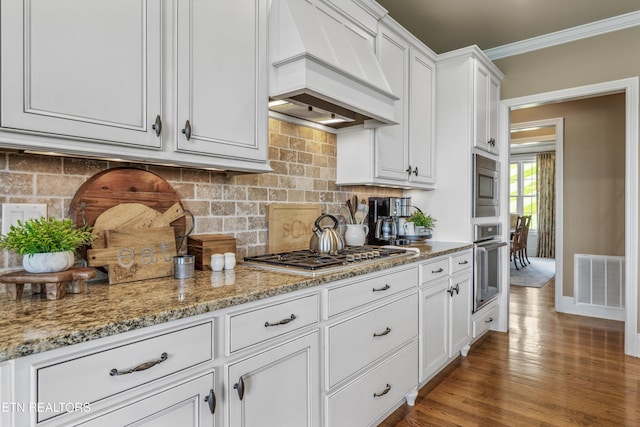436 Silent River Ln, Loudon, TN 37774 - kitchen with custom exhaust hood, appliances with stainless steel finishes, crown molding, tasteful backsplash, and white cabinetry