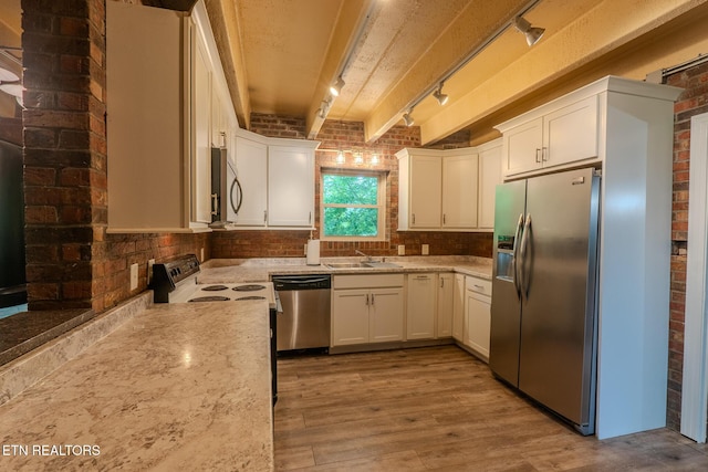 944 Smoky Mountain View Ct, Seymour, TN 37865 - kitchen featuring appliances with stainless steel finishes, brick wall, a sink, rail lighting, and wood finished floors