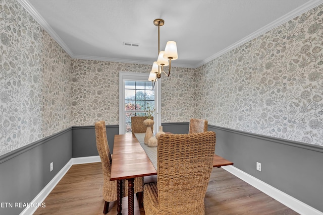 2034 Cherokee Dr, Maryville, TN 37801 - dining area with wainscoting, wood finished floors, wallpapered walls, crown molding, and baseboards