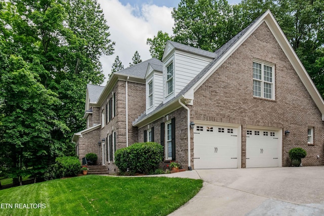 129 Whippoorwill Dr, Oak Ridge, TN 37830 - view of front facade with concrete driveway, brick siding, a front lawn, a garage, and a shingled roof