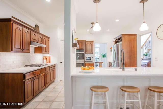 129 Whippoorwill Dr, Oak Ridge, TN 37830 - kitchen with appliances with stainless steel finishes, a sink, a breakfast bar area, under cabinet range hood, and recessed lighting