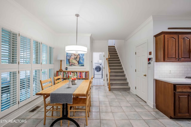 129 Whippoorwill Dr, Oak Ridge, TN 37830 - dining area featuring washer / dryer, ornamental molding, light tile patterned flooring, and stairway