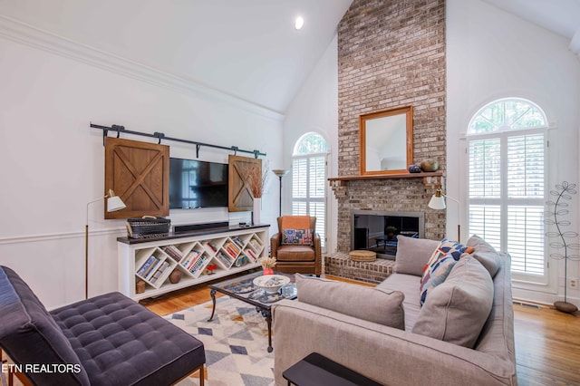 129 Whippoorwill Dr, Oak Ridge, TN 37830 - living area featuring high vaulted ceiling, plenty of natural light, wood finished floors, a fireplace, and ornamental molding