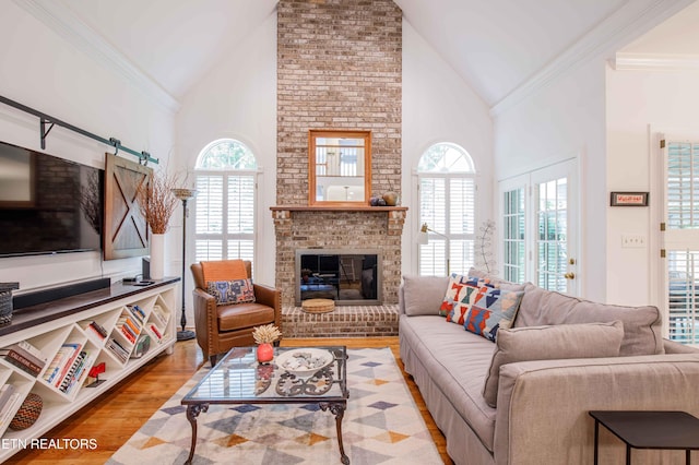 129 Whippoorwill Dr, Oak Ridge, TN 37830 - living area featuring high vaulted ceiling, ornamental molding, healthy amount of natural light, wood finished floors, and a brick fireplace