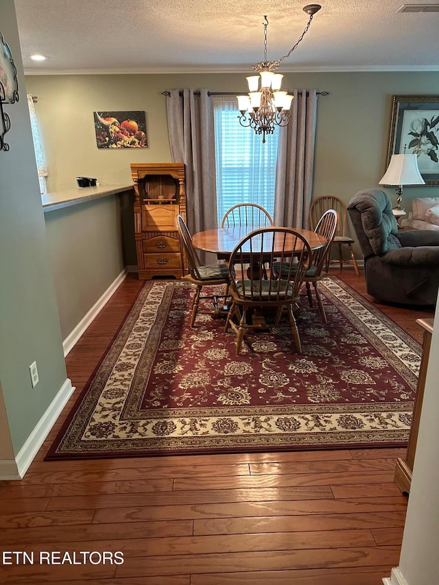 5230 Brig Ln, Knoxville, TN 37914 - dining area featuring hardwood / wood-style floors, a chandelier, ornamental molding, a textured ceiling, and baseboards