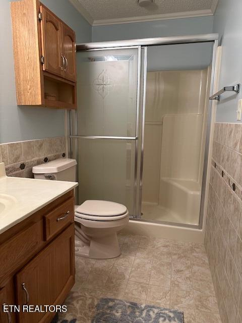 5230 Brig Ln, Knoxville, TN 37914 - full bathroom featuring tile walls, toilet, vanity, ornamental molding, and a shower stall