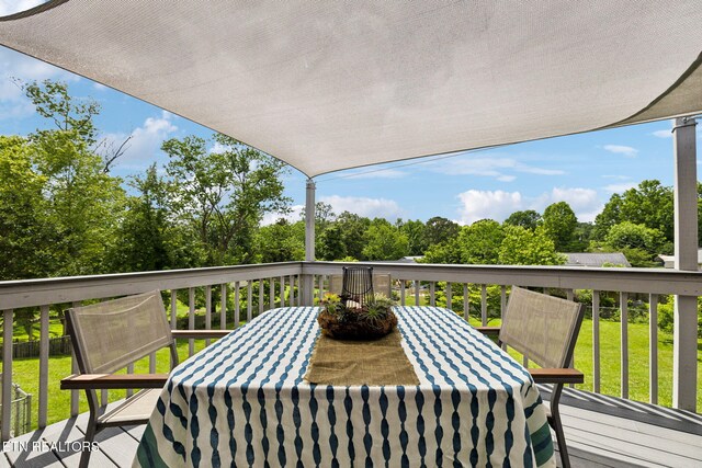 7613 Scenic View Dr, Knoxville, TN 37938 - wooden deck with outdoor dining space, view of wooded area, and a lawn