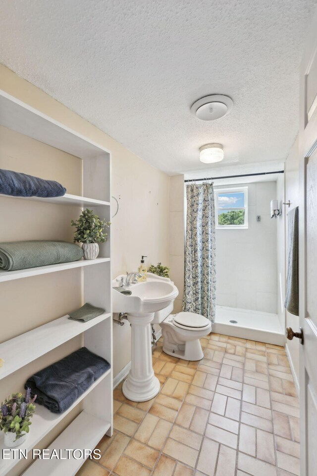 7613 Scenic View Dr, Knoxville, TN 37938 - full bath featuring a stall shower, toilet, a textured ceiling, brick patterned flooring, and baseboards