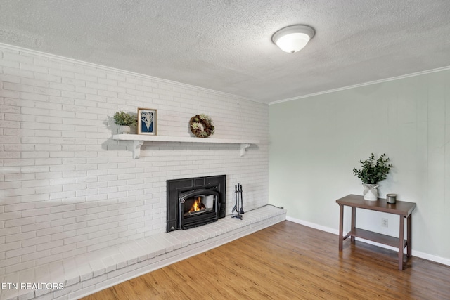 7613 Scenic View Dr, Knoxville, TN 37938 - unfurnished living room with a textured ceiling, ornamental molding, wood finished floors, a brick fireplace, and baseboards