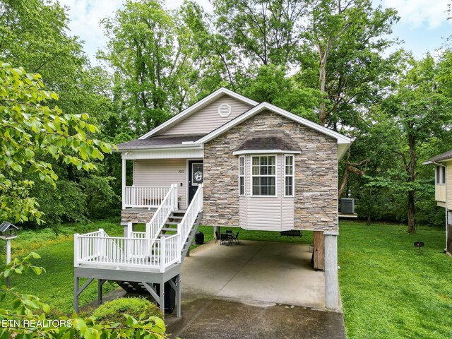 2032 Slippery Rock Cir, Pigeon Forge, TN 37862 - view of front facade with stone siding, a front yard, a patio area, view of wooded area, and a deck