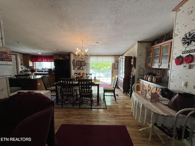 130 New Light Cir, Winfield, TN 37892 - dining space featuring a textured ceiling, a chandelier, wood finished floors, wallpapered walls, and healthy amount of natural light