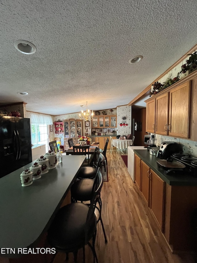 130 New Light Cir, Winfield, TN 37892 - kitchen featuring black fridge, a textured ceiling, dark countertops, a chandelier, and brown cabinets