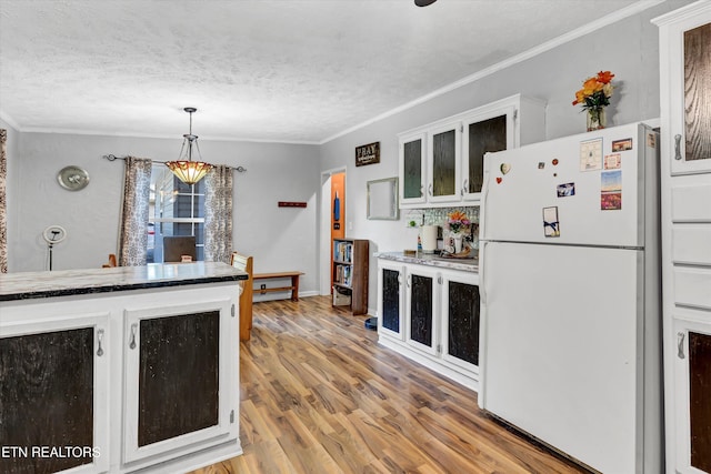 501 Park Ave, Clinton, TN 37716 - kitchen with freestanding refrigerator, light wood-type flooring, crown molding, a textured ceiling, and glass insert cabinets