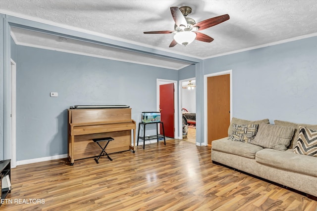 501 Park Ave, Clinton, TN 37716 - living area featuring a textured ceiling, ceiling fan, wood finished floors, baseboards, and ornamental molding