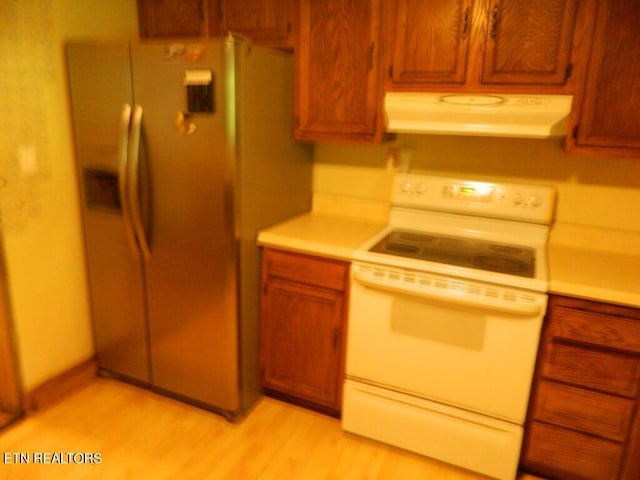 232 Sallings Rd, Luttrell, TN 37779 - kitchen with white range with electric stovetop, exhaust hood, light countertops, stainless steel fridge with ice dispenser, and light wood finished floors