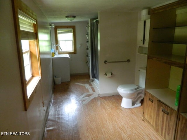 232 Sallings Rd, Luttrell, TN 37779 - bathroom with toilet, a stall shower, wood finished floors, a sink, and baseboards