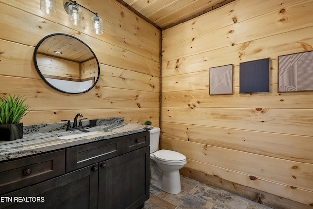 1705 Pkwy View Ct, Sevierville, TN 37876 - bathroom featuring wooden ceiling, vanity, toilet, wooden walls, and stone finish flooring