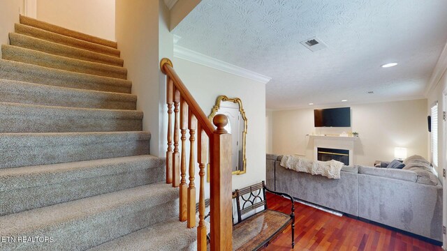 1859 Poplar Hill Rd, Knoxville, TN 37922 - stairway featuring wood finished floors, a glass covered fireplace, recessed lighting, crown molding, and a textured ceiling