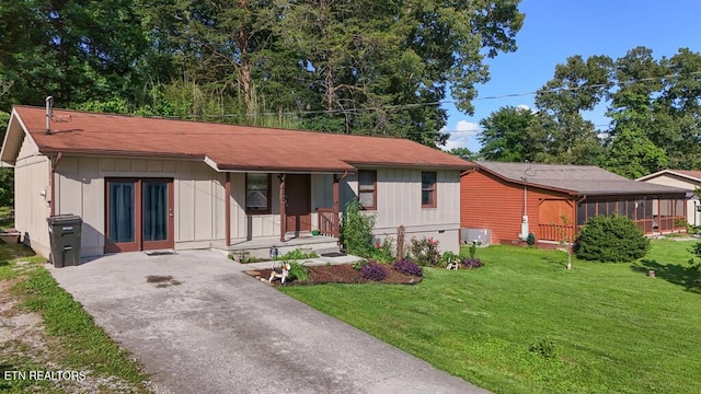 233 Doe Run Blvd, Clinton, TN 37716 - view of front of home featuring a front yard, asphalt driveway, a porch, board and batten siding, and a sunroom