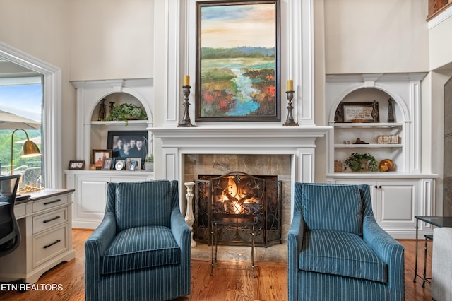 759 Indian Mountain Rd, Jellico, TN 37762 - living area with built in features, a tiled fireplace, and light wood-style flooring