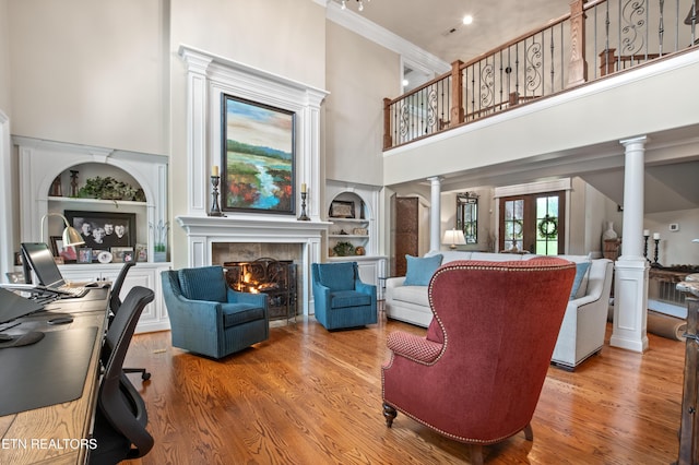 759 Indian Mountain Rd, Jellico, TN 37762 - living area featuring a high ceiling, ornate columns, built in features, a tile fireplace, and wood finished floors
