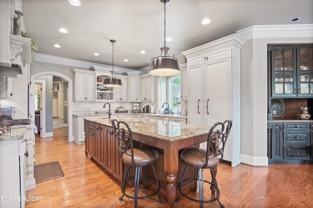 759 Indian Mountain Rd, Jellico, TN 37762 - kitchen featuring arched walkways, white cabinetry, a center island with sink, light wood-type flooring, and recessed lighting