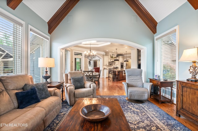 759 Indian Mountain Rd, Jellico, TN 37762 - living room featuring arched walkways, high vaulted ceiling, light wood-type flooring, a chandelier, and beamed ceiling