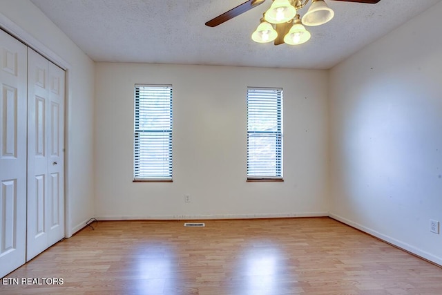 4003 Valley View Dr Unit 6, Knoxville, TN 37917 - unfurnished bedroom with light wood-type flooring, a closet, a textured ceiling, baseboards, and a ceiling fan