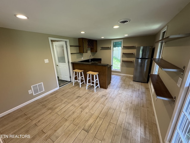 118 Toqua Club Way, Loudon, TN 37774 - kitchen with freestanding refrigerator, dark countertops, a peninsula, light wood-type flooring, and baseboards